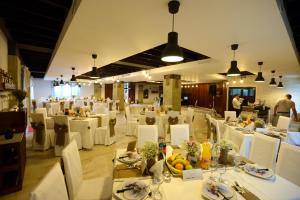 a dining room with white tables and white chairs at Complex HAMAK in Iaşi