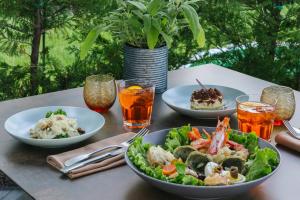 a table with plates of food and drinks on it at Almar Jesolo Resort & Spa in Lido di Jesolo