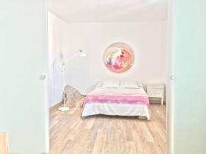 a bedroom with a bed and a painting on the wall at Casa ALBAYZÍN in Salobreña