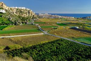 a road in the middle of a field with a mountain at Casa ALBAYZÍN in Salobreña