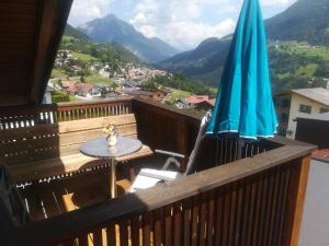 een balkon met een tafel en een parasol bij Ferienwohnung Eiter Anita in Wenns