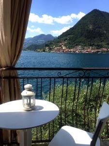 un tavolo e sedie su un balcone con vista sul lago di IseoLakeRental - Casa Stella d'Acqua a Sulzano