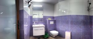 a purple bathroom with a toilet and a sink at Casa Eden Jupiter in Jupiter