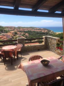 un patio con mesas y sillas y vistas al océano en Sardegna-Ferienwohnung mit emotionale Meeres Blick, en Torre dei Corsari