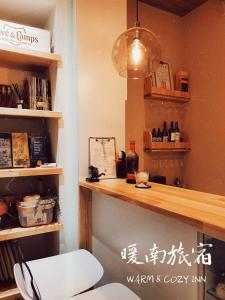 una habitación con una encimera y una estantería con botellas en Warm & Cozy Inn, en Hengchun