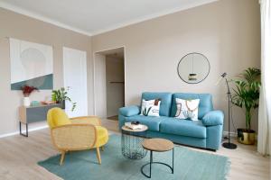- un salon avec un canapé bleu et une chaise dans l'établissement PALMA Cozy - minutes aways from everything!, à Biarritz