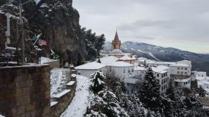 un villaggio ricoperto di neve con una chiesa sullo sfondo di Los Estribos a Zahara de la Sierra