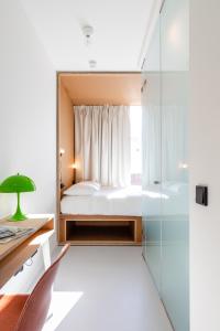 a bedroom with a bed and a glass shower at the bellhop in Rotterdam
