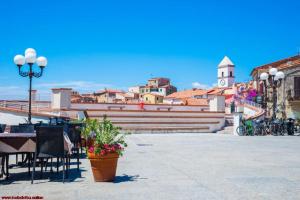 a group of tables and chairs and a street light at Casa Iris in Capoliveri