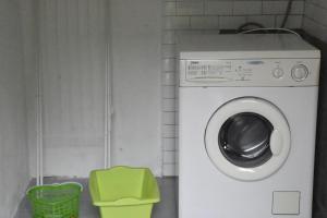 uma máquina de lavar roupa na casa de banho com um banco verde em casa vacanza DolceVita em Averara