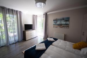 a bedroom with a large bed and a television at Apartament Feniks 12 - 63 m2 in Świnoujście