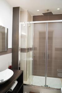 a bathroom with a glass shower and a sink at Hotel Cimarosa in Naples