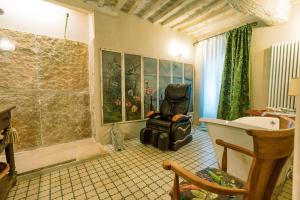 a bathroom with a sink and a chair in a room at Beccofino in Pienza