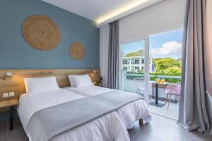 a bedroom with a large bed and a balcony at La Maison Corfu - Adults Only in Ýpsos +63 photos