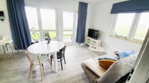 a living room with a table and a couch at Gąski Baltic Lark Dom 100m2 3 sypialnie 2 łazienki Sauna Prywatny teren in Gąski