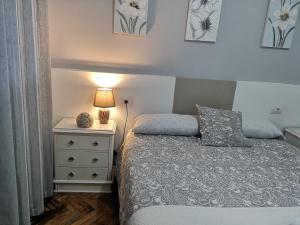 1 dormitorio con 1 cama y mesita de noche con lámpara en Ático Camino De Santiago 2, en Sarria