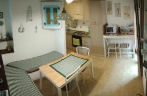 a small kitchen with a table and a table and chairs at Casa Alessia in Villasimius