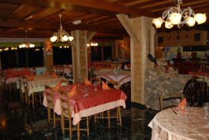 un comedor con mesas con manteles rojos y blancos en Hôtel De La Couronne, en Mijoux