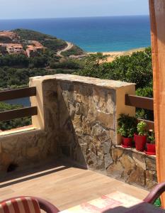 un balcón con una pared de piedra y el océano en Sardegna-Ferienwohnung mit emotionale Meeres Blick, en Torre dei Corsari