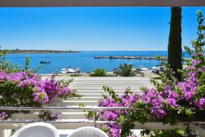 a view of the water from a balcony with purple flowers at Apartments Bella Sky in Novalja