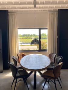 ein Esszimmer mit Tisch und Stühlen und einem Fenster in der Unterkunft Maashuys in Lanaken + 25 Fotos