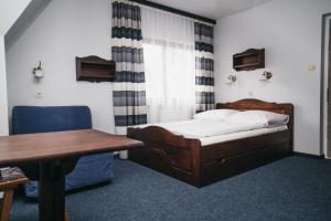 布科維納塔特贊斯卡的住宿－Hawrań Bukowina，卧室配有1张床、1张桌子和1把椅子