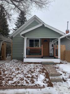 ein kleines Haus mit einer Veranda im Schnee in der Unterkunft Dillon Ave Homes in Cheyenne