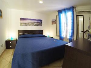 マリーナ・ディ・ラグーザにあるRosa dei Ventiのベッドルーム(青いベッド1台、青いカーテン付)