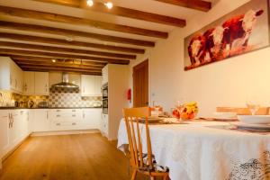 a kitchen with a table with a white table cloth at The Old Cow Byre in Lealholm