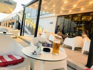 a table with a glass of beer sitting on it at Sunset Apartman Novi Vinodolski in Novi Vinodolski
