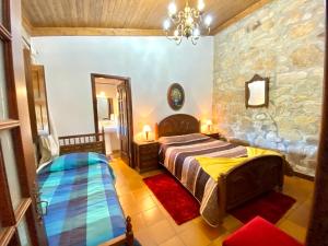 a bedroom with a bed and a stone wall at Casa do Outeirinho- Turismo Rural in Penedo