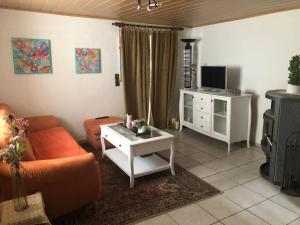 a living room with a couch and a tv at Ferienhaus in Sankt Aldegund