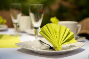 un plato con una servilleta amarilla en una mesa en Börse Coswig, en Coswig