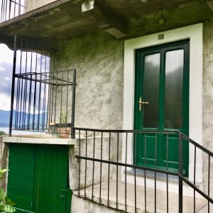 eine grüne Tür an der Seite eines Gebäudes in der Unterkunft Cosy Place in Perledo