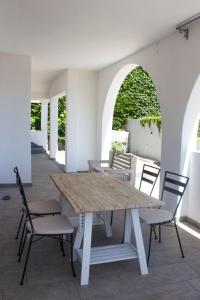 un tavolo e sedie in legno in un patio con arco. di Residenze Branca I SeaView a Orosei