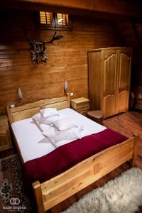 una camera da letto con un grande letto in una camera in legno di Pension Vanatorul a Vatra Dornei
