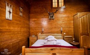 een slaapkamer met een bed in een houten kamer bij Pension Vanatorul in Vatra Dornei