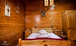 a bedroom with a bed in a wooden room at Pension Vanatorul in Vatra Dornei