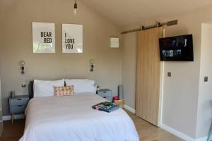 a bedroom with a large white bed and a television at The Hideaway Portaferry in Portaferry