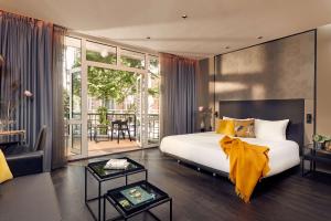 a bedroom with a large bed and a living room at Park Plaza Vondelpark Amsterdam in Amsterdam