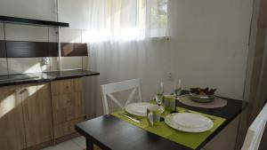 una piccola cucina con tavolo, piatti e bicchieri di LEA Apartments a Liepāja