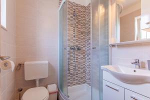 a bathroom with a shower and a toilet and a sink at Room Laudina in Cres