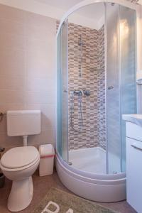 a bathroom with a shower and a toilet and a tub at Room Laudina in Cres