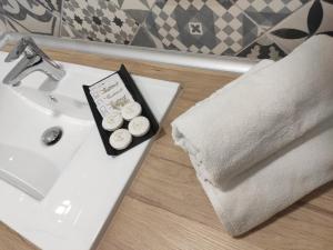 a bathroom sink with a towel and two cupcakes on it at Hospédate Pontevedra in Pontevedra