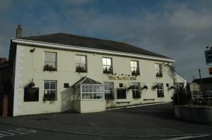 een wit gebouw met planten op de ramen bij The Royal Inn in St Austell