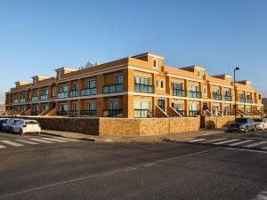 a large orange building with cars parked in front of it at Family Heaven - No Stress Holidays in Cotillo