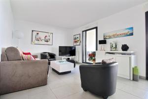 a living room with two chairs and a couch and a tv at O de mer D101 in La Ciotat