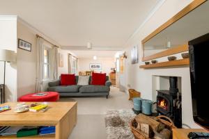 ein Wohnzimmer mit einem Sofa und einem Kamin in der Unterkunft Mews Hill, 5 bedroom New Forest Holiday Cottage in Fordingbridge