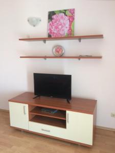 a tv cabinet with a television on top of it at Apartments Diana in Orebić