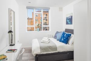 a bedroom with a bed and a desk and a window at Skyline Serviced Apartments - Vauxhall in London
